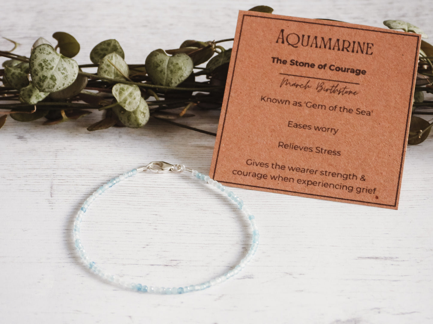 dainty aquamarine gemstone stacking bracelet with properties card