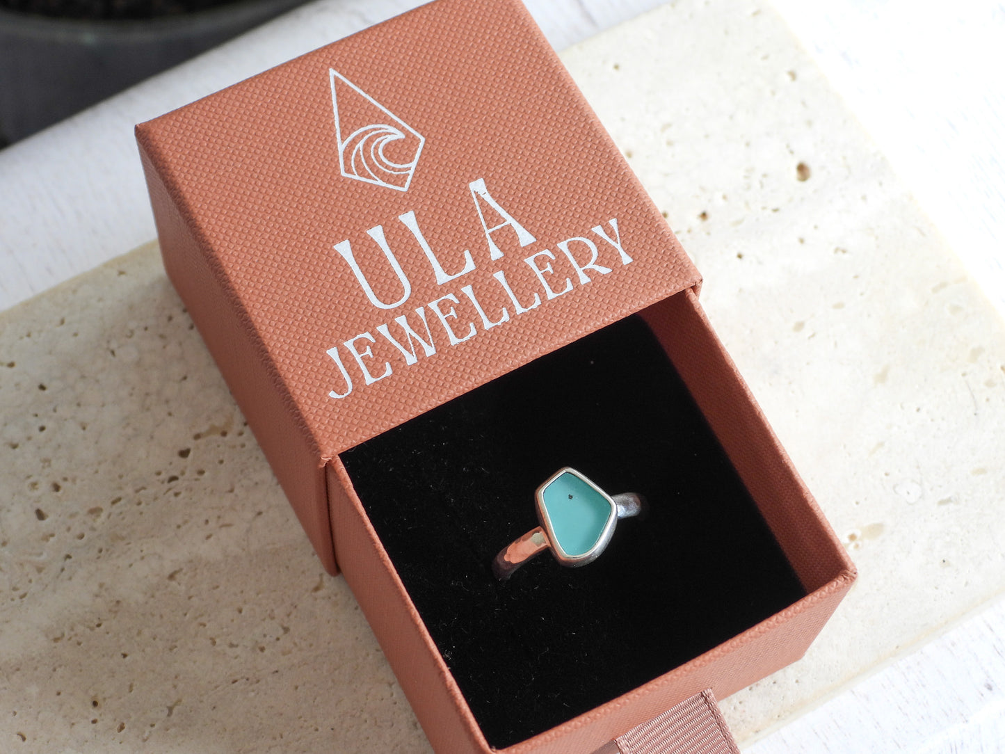 turuoise seaglass and silver ring with a box with Ula Jewellery logo on