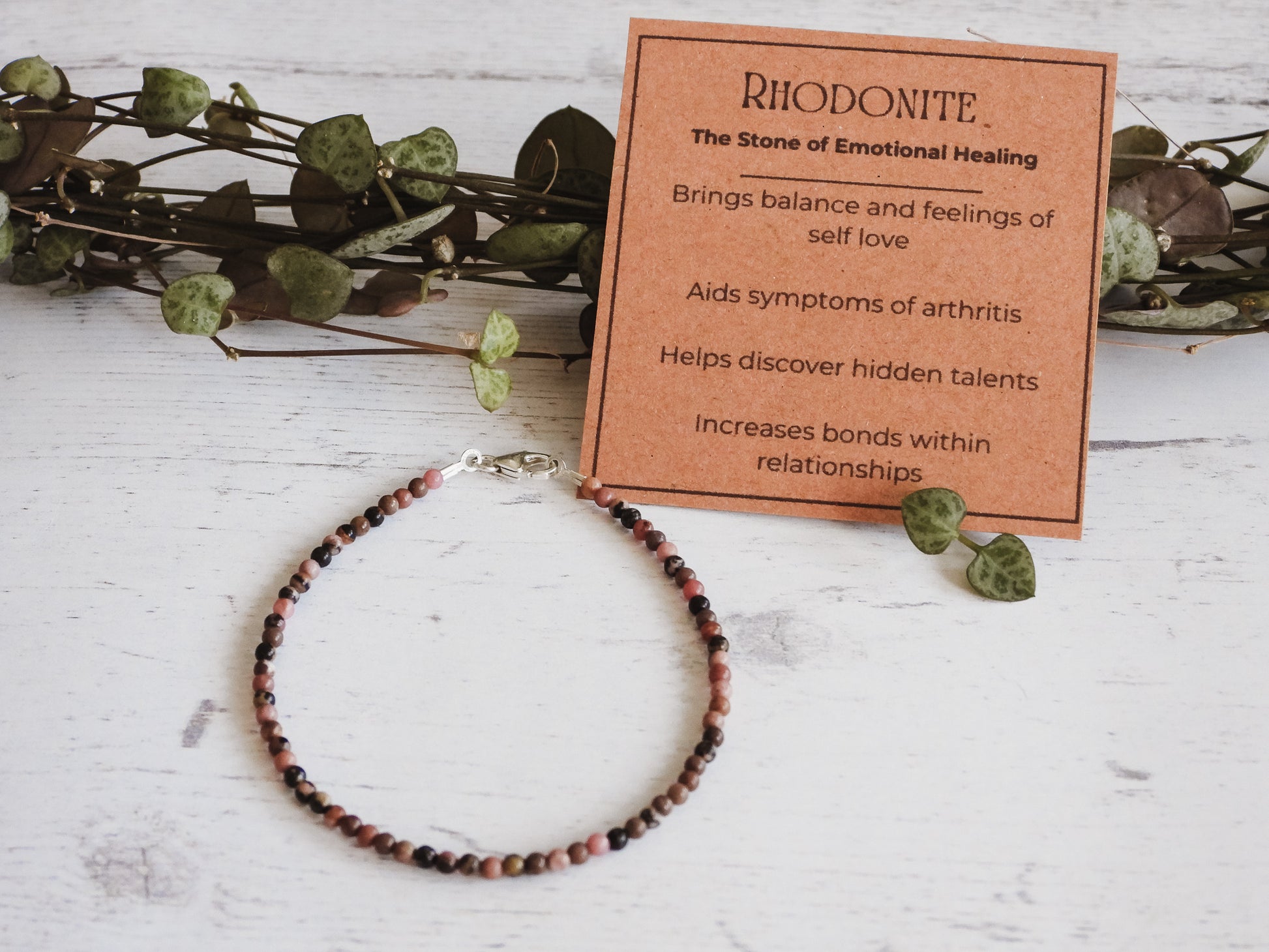 pink and black minimalist rhodonite gemstone beaded bracelet with properties card
