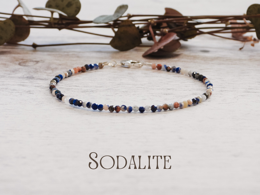 dainty Multicolored beaded bracelet on a light wooden surface with 'Sodalite' text below.